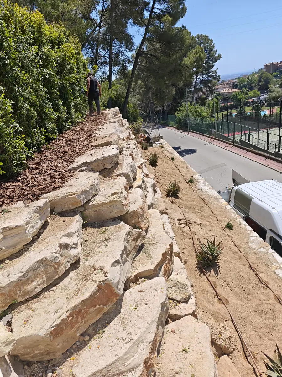Muro de piedra natural con plantación e instalación de riego